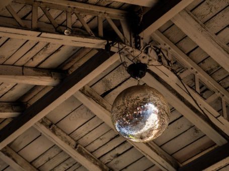 Eine Discokugel hängt an einer alten Holzdecke
